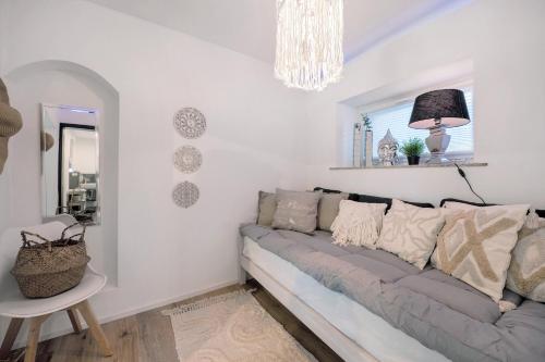 a living room with a couch and a chandelier at My Little Suite in Illingen