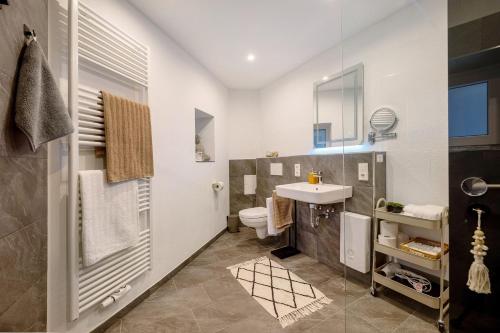 a bathroom with a white sink and a toilet at My Little Suite in Illingen