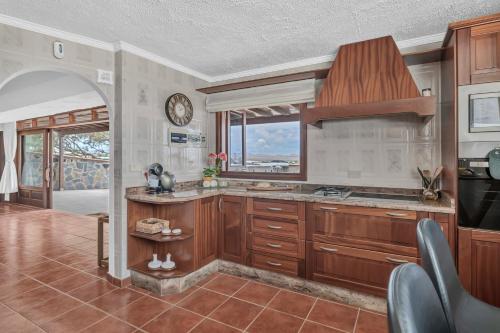 a kitchen with wooden cabinets and a large window at Villalmar in Famara
