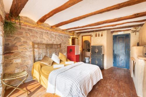 a bedroom with a bed and a stone wall at Duende in Olba