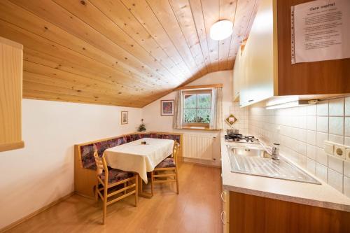 a dining room with a table and a kitchen at Wieserhof Ferienwohnung Priml in Sarntal