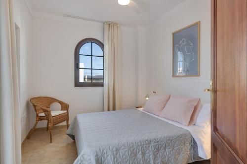 a bedroom with a bed and a chair and a window at Casa Fama con piscina privada clima in Yaiza