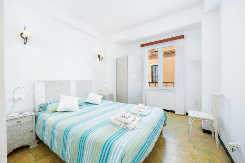 a white bedroom with a bed with towels on it at Brisas Vista Mar in Sa Ràpita