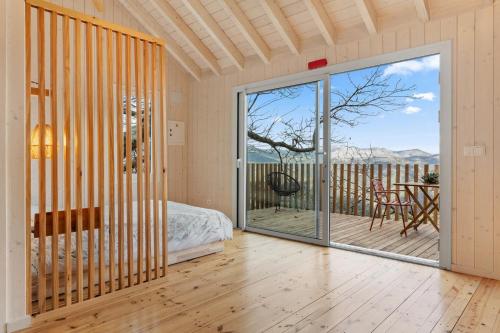 a room with a bed and a glass door with a balcony at Cabañas Entre Castaños in Jubrique