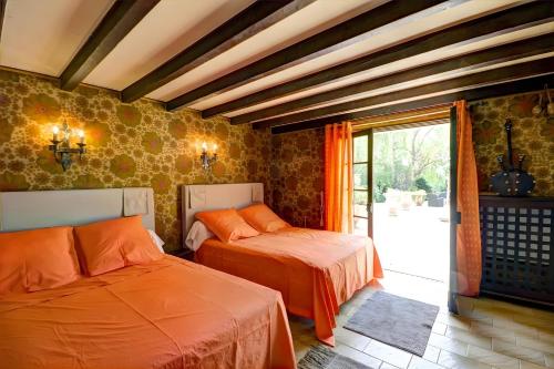a bedroom with two beds and a sliding glass door at Gîte Des Roties in Poncins