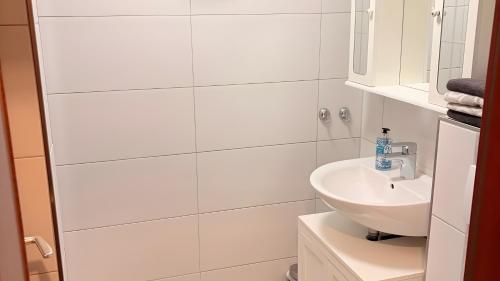 a white bathroom with a sink and a mirror at Ferienwohnung Schöntal in Ludwigswinkel