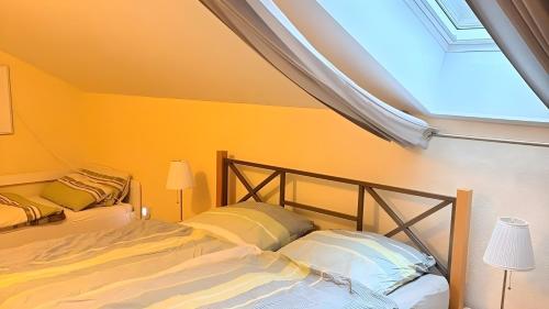 a bedroom with a bed with yellow walls and a skylight at Ferienwohnung Schöntal in Ludwigswinkel