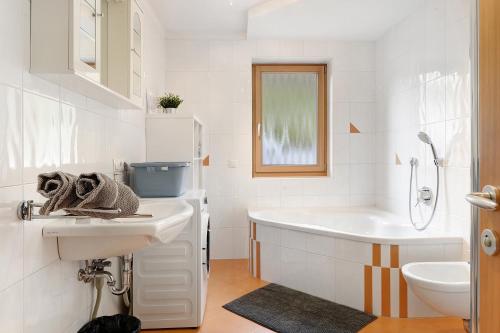 a white bathroom with a tub and a sink at Xxl-appartement Moarhof in Sand in Taufers