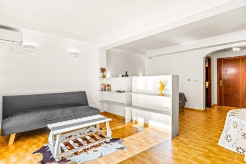 a living room with a bed and a table at Unique Apartahotel 4-2 in Torrevieja