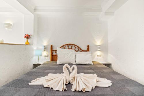 a bedroom with a bed with a dress on it at Unique Apartahotel 4-2 in Torrevieja