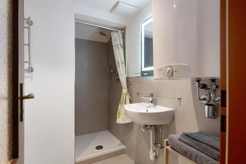 a small bathroom with a sink and a shower at Haus am See - Wohnung Jenner in Schönau am Königssee