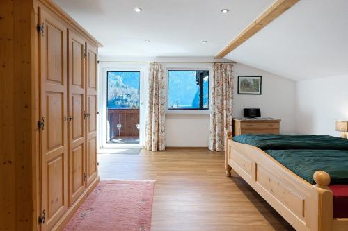 a bedroom with a bed and a large window at Haus am See - Wohnung Jenner in Schönau am Königssee