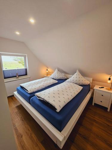 a bedroom with two beds and a window at Hus Matje in Langeneß