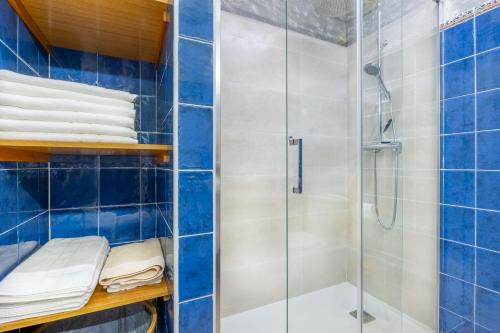 a bathroom with a shower and blue tiles at Las Candelas - Las Sopeñas in Oreña