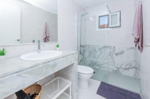 a bathroom with a sink and a toilet and a shower at Tranquilo apto con preciosa cala in Cala en Forcat