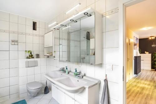 a white bathroom with a sink and a toilet at Ferienwohnung Goldstadtblick in Pforzheim