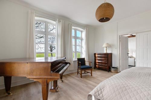 a bedroom with a piano and a bed at Sophienhof in Kronprinzenkoog