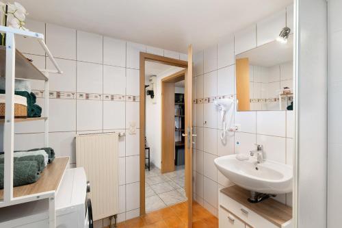 a white bathroom with a sink and a mirror at Ferienwohnung Knittlingen in Knittlingen
