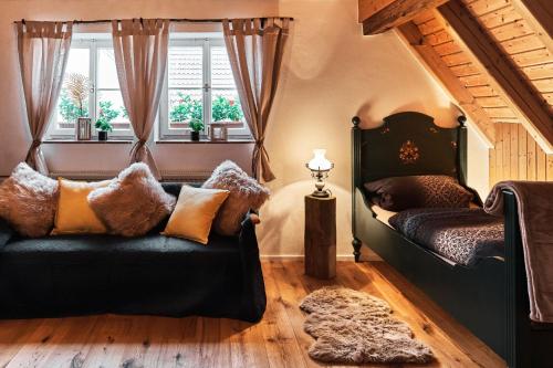 a bedroom with a couch and a bed and windows at Ferienhaus Lilace in Böttingen