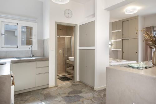 a white kitchen with a sink and a shower at Ariston House in Porto Heli
