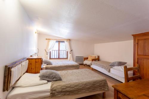 a bedroom with three beds and a window at L'Alpazen Jouve Duplex in Saint-Véran