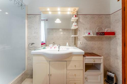 a bathroom with a white sink and a mirror at Gîte Le Séguret in Entrechaux