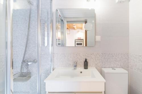 a white bathroom with a sink and a shower at Casa Das Batatas in Odeceixe