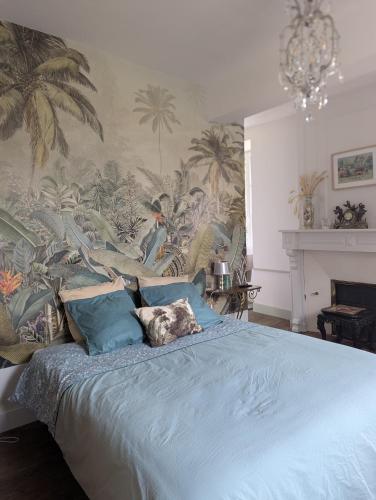 a bedroom with a blue bed with a mural of palm trees at Chateau De Chaunac in Naves