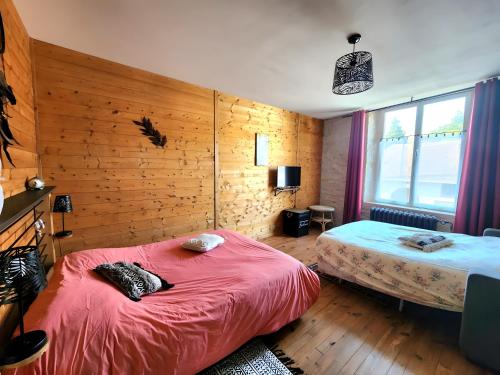 a bedroom with two beds and a window at Gîte avec bar et four à pizza in Étreval