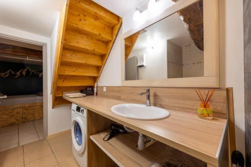 a bathroom with a sink and a washing machine at Gite d'Orgeix - Ax-les-Thermes in Orgeix