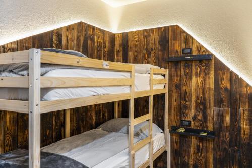 two bunk beds in a room with wooden walls at Ride Home 2 in Commezzadura
