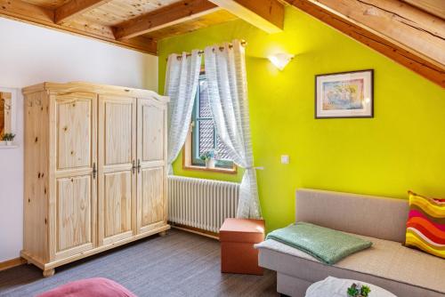 a living room with a couch and a green wall at Dachwohnung Im Landhausstil in Meiningen