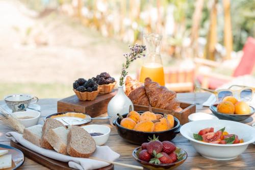 a table topped with lots of different types of bread and fruit at La Meridiana in Capo Vaticano