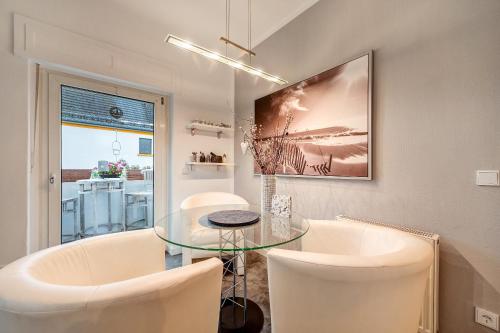 a dining room with a glass table and white chairs at Ferienwohnung Bettersleepat8 in Limburg an der Lahn