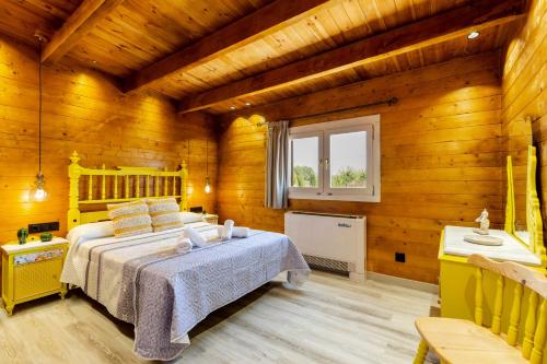 a bedroom with a bed in a room with wooden walls at Cortijo la Jimena 2 in Benablón