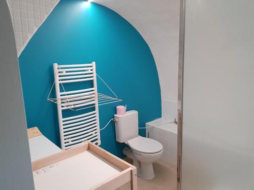 a bathroom with a toilet and a blue wall at Rives du Tarn in Peyreleau