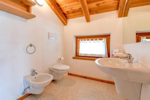 a bathroom with two sinks and a toilet and a window at Agriturismo Chalet Casa Al Campo in Giustino