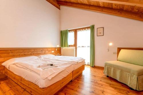 a bedroom with a large bed and a window at Agriturismo Chalet Casa Al Campo in Giustino