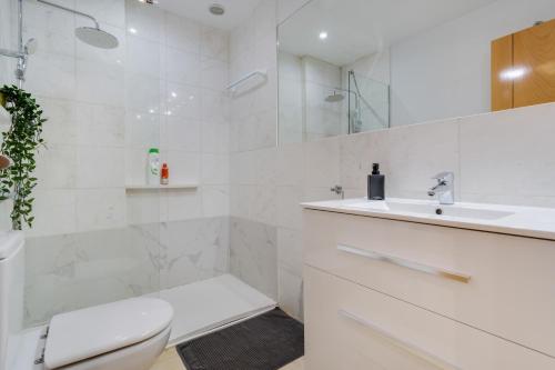 a white bathroom with a toilet and a sink at Apartamento Centro con Aparcamiento in Santa Cruz de Tenerife