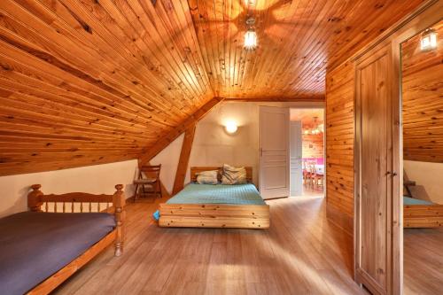 a bedroom with two beds in a room with a wooden ceiling at Gite des Granges in Tréminis
