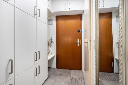 a hallway with white cabinets and a wooden door at Steuermann am Steinhuder Meer in Wunstorf