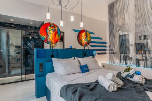 a bedroom with a blue bed with towels on it at Artrock Experience Loft Gallery in Ermoupoli