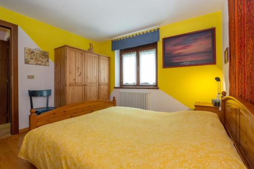 a bedroom with a bed and a yellow wall at Chambre d'hôtes dans les Alpes in Conclonaz