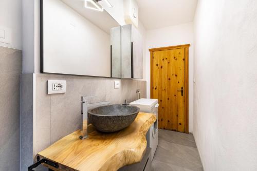 a bathroom with a stone sink on a wooden counter at Casa Fiocco di Neve in Vigo di Cadore