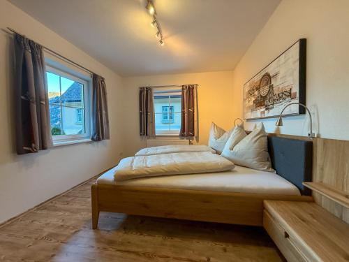 a bedroom with a large bed with two windows at Die Kromarin in Kleinsölk