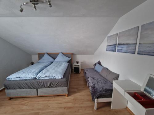 a bedroom with a bed and a couch at Ferienwohnung Arnsberger Wald in Möhnesee
