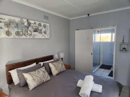 a bedroom with a bed with two towels on it at 25 On Main Struisbaai in Struisbaai