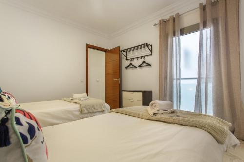 a bedroom with two beds and a window at Apartamento Rolycar 201 in Icod de los Vinos