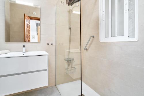 a bathroom with a shower and a sink and a mirror at Casa Alina in Nerja