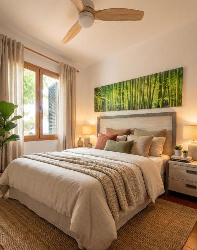 a bedroom with a large bed with a ceiling fan at Costa Arenal 5 in Arenal d'en Castell